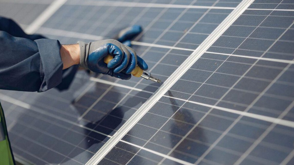 man-with-white-helmet-near-solar-panel-995x560